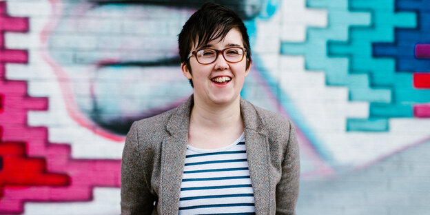 Lyra McKee vor einer bemalten Wand, lächelnd