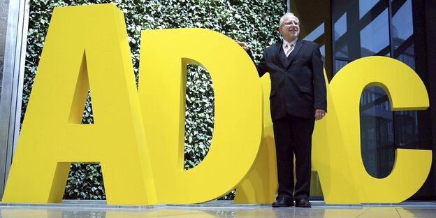 ADAC-Präsident August Markl posiert vor riesigen, gelben Buchstaben. ADAC-Präsident August Markl posiert vor riesigen, gelben Buchstaben.