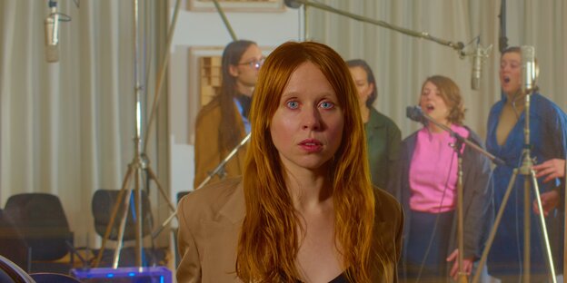 Eine Frau guckt erschrocken vor einer Leinwand, die einen Film zeigt Eine Frau guckt erschrocken vor einer Leinwand, die einen Film zeigt