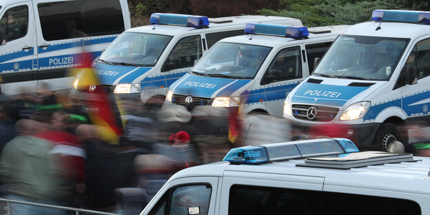 Demonstranten mit Deutschlandfahnen ziehen an Polizeiautos vorbei Demonstranten mit Deutschlandfahnen ziehen an Polizeiautos vorbei