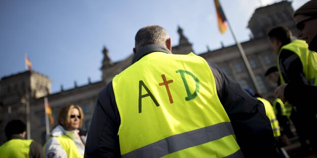 Ein Demonstrant trägt die Buchstaben AfD auf der Gebweste, das f ist als Kreuz dargestellt Ein Demonstrant trägt die Buchstaben AfD auf der Gebweste, das f ist als Kreuz dargestellt