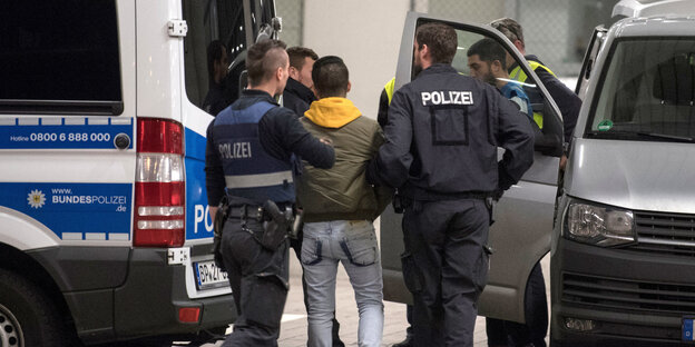 Polizisten führen einen Mann ab Polizisten führen einen Mann ab