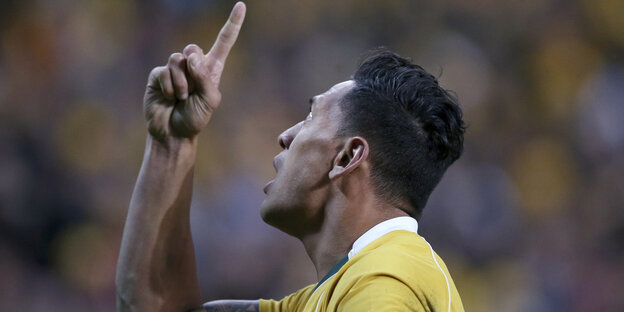 Der Sportler Folau steht auf dem Spielfeld und zeigt mit dem Zeigefinger Richtung Himmel Der Sportler Folau steht auf dem Spielfeld und zeigt mit dem Zeigefinger Richtung Himmel