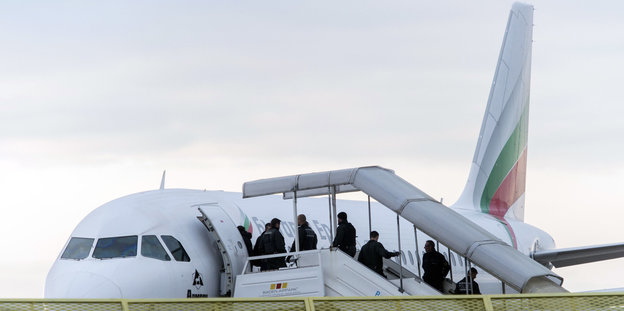 Abgelehnte Asylbewerber steigen in ein Flugzeug