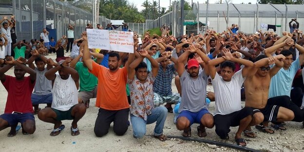Menschen knien auf dem Boden und kreuzen ihre Arme Menschen knien auf dem Boden und kreuzen ihre Arme