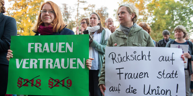 Zwei Frauen protestieren mit Plakaten gegen den Paragrafen 219a