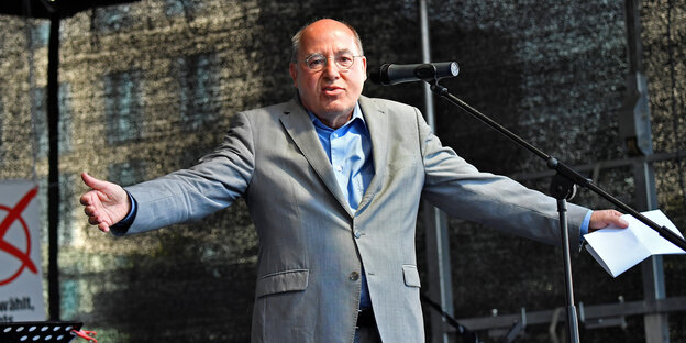 Gregor Gysi breitet auf einer Bühne die Arme aus Gregor Gysi breitet auf einer Bühne die Arme aus