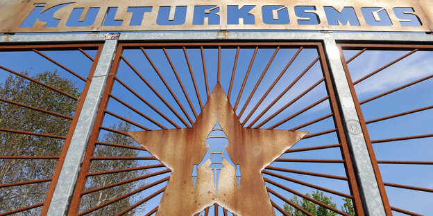 Das Wort «Kulturkosmos» und ein Stern mit der typischen «Fusion-Rakete» sind an einem Eingangstor zu sehen Das Wort «Kulturkosmos» und ein Stern mit der typischen «Fusion-Rakete» sind an einem Eingangstor zu sehen