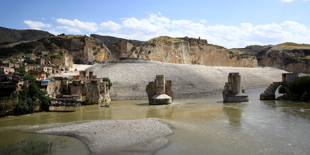 Die alte Stadt Hasankeyf am Tigris mit einer alten Brücke und historischen Bauten erstrahlt in der Abenddämmerung. Die alte Stadt Hasankeyf am Tigris mit einer alten Brücke und historischen Bauten erstrahlt in der Abenddämmerung.