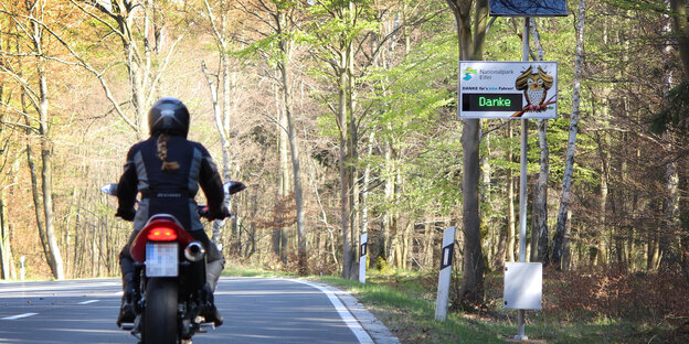 Ein Motorrad fährt in der Eifel an einer Geschwindigkeitsanzeige vorbei. Ein Motorrad fährt in der Eifel an einer Geschwindigkeitsanzeige vorbei.