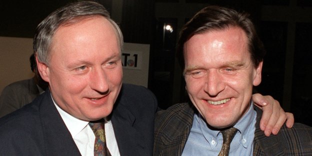 Auf einem Foto aus dem Jahr 1990 liegen sich Oskar Lafontaine und Gerhard Schröder im Arm