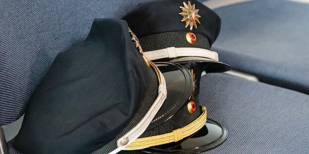 Polizeimützen auf einem Stuhl Polizeimützen auf einem Stuhl