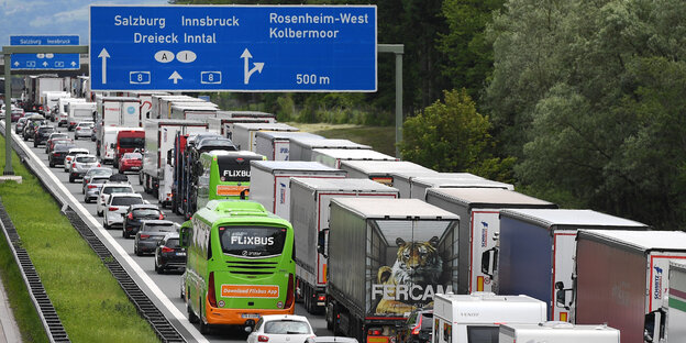 Auf einer überfüllten Autobahn steht ein grüner Bus des Fernreisenanbieters Flixbus neben Lastern Auf einer überfüllten Autobahn steht ein grüner Bus des Fernreisenanbieters Flixbus neben Lastern