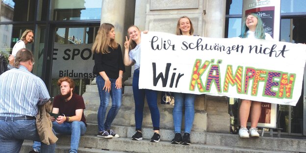 Drei Schülerinnen halten ein Plakat mit der Aufschrift: "Wir scwänzen nicht, wir kämpfen". Drei Schülerinnen halten ein Plakat mit der Aufschrift: "Wir scwänzen nicht, wir kämpfen".