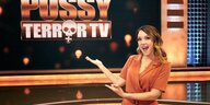 Kebekus präsentiert das Logo von Pussy Terror TV