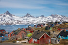 Schneebedeckte Berge und Häuser in Grönland