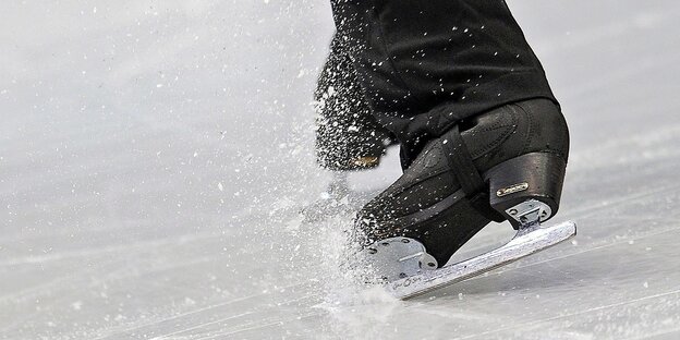 Schwarze Schlittschuhe fahren über das Eis