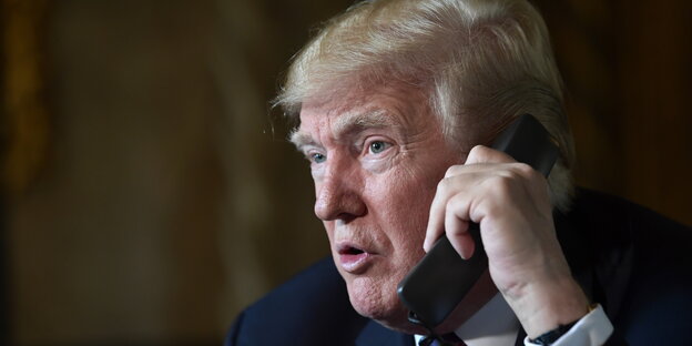 Donald Trump mit einem Telefonhörer am Ohr