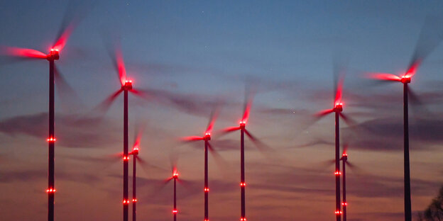 Windräder mit roten Positionslichtern vor Sonnenuntergang