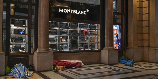 Obdachlose schlafen in Turin vor einem geschlossenen Montblanc-Laden