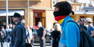 Jemand trägt eine Gesichtsmaske in Deutschlandfarben