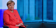 Angela Merkel trägt ein rosafarbenes Jackett und lächelt