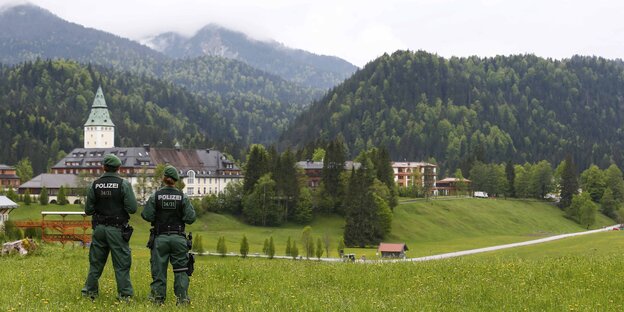 Zwei Polizisten blicken auf Schloss Elmau Zwei Polizisten blicken auf Schloss Elmau