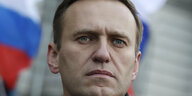 Porträt von Alexej Nawalny vor einer russischen Fahne
