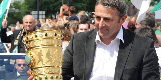 Klaus Allofs hält den DFB-Pokal. Klaus Allofs hält den DFB-Pokal.