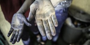 Hände von Kindern, die in der Jeansproduktion in der Türkei arbeiten sind blau gefärbt