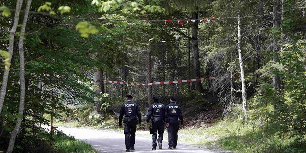 Polizisten von hinten auf einem Waldweg Polizisten von hinten auf einem Waldweg
