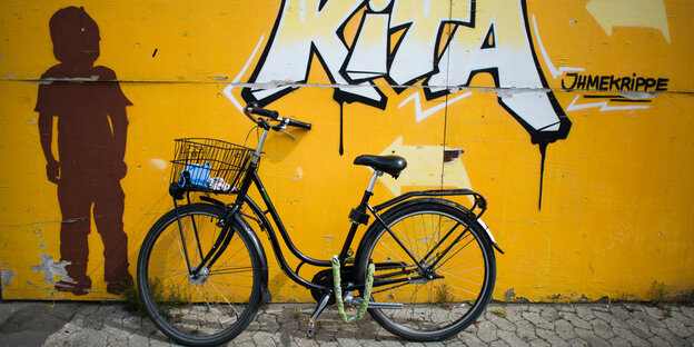 Ein Fahrrad lehnt an einer Wand des Ihmezentrums in Hannover. Darüber ein Grafitti "Kita". Ein Fahrrad lehnt an einer Wand des Ihmezentrums in Hannover. Darüber ein Grafitti "Kita".