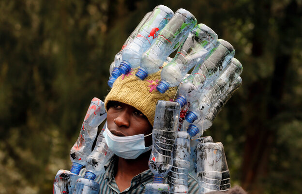 Ein Klimaaktivist aus Nairobi hat eine Mütze auf an der viele Plastikflaschen hängen. Er trägt auch eine Maske.