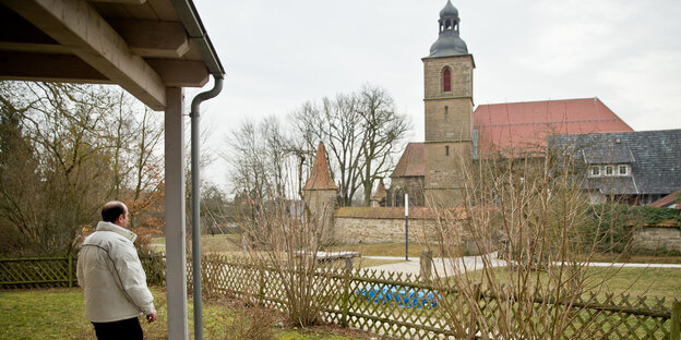 Syrischer Flüchtling blickt auf Kirche in Bayern Syrischer Flüchtling blickt auf Kirche in Bayern
