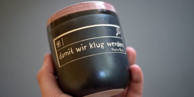 Ein Becher zeigt die Aufschrift „damit wir klug werden“.