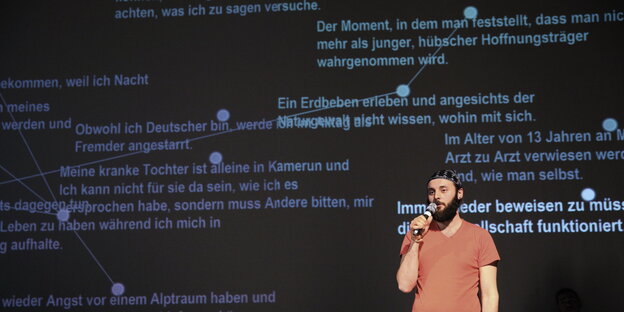 Junger Mann mit Mikro vor Leinwand Junger Mann mit Mikro vor Leinwand