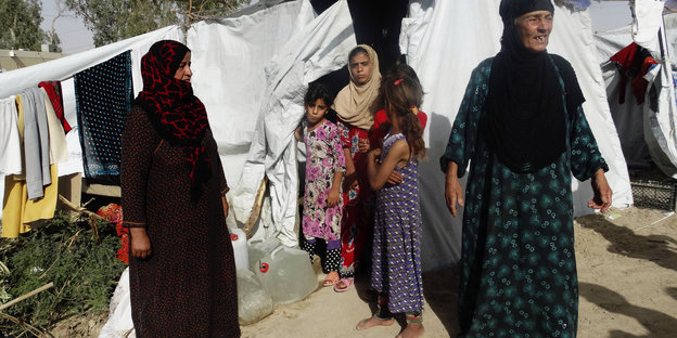 Frauen und Kinder vor einem Zelt