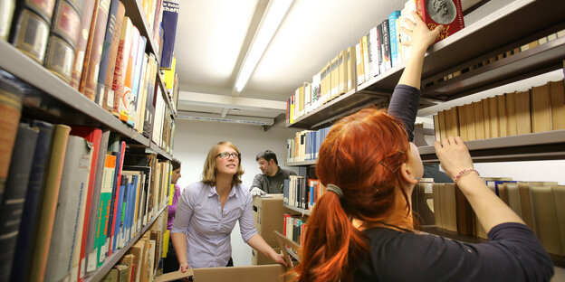 Mitarbeiter der Uni Rostock räumen Bücher in Regale Mitarbeiter der Uni Rostock räumen Bücher in Regale