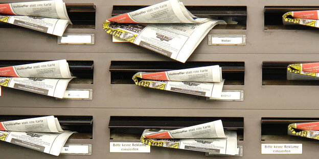 Zeitungen hängen aus Briefkästen heraus