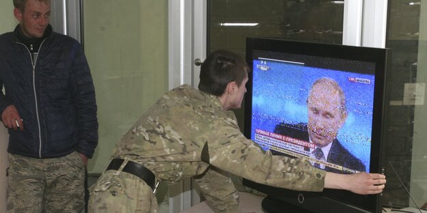 Ukrainische Separatisten schauen sich Putin im russischen Fernsehen an. Ukrainische Separatisten schauen sich Putin im russischen Fernsehen an.