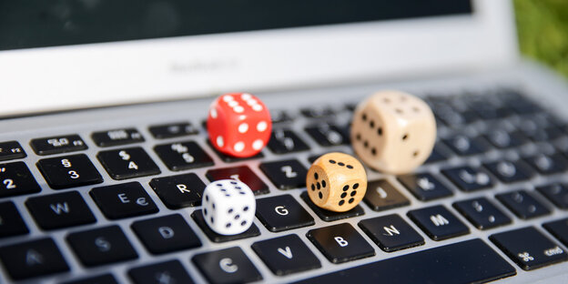 Vier Würfel liegen auf einer Computertastatur Vier Würfel liegen auf einer Computertastatur