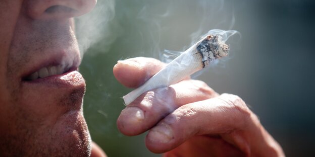 Ein Mann raucht einen Joint Ein Mann raucht einen Joint