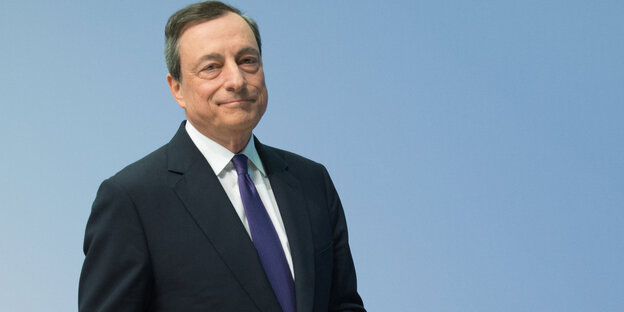 EZB-Chef Draghi steht vor einem hellblauen Hintergrund EZB-Chef Draghi steht vor einem hellblauen Hintergrund
