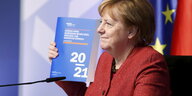 Angela Merkel hält das aktuellen Gutachten der Wirtschaftsweisen in der Hand.