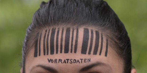 Eine Frau hat einen Barcode auf die Stirn gezeichnet Eine Frau hat einen Barcode auf die Stirn gezeichnet