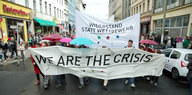 Demotransparent mit der Aufschrift „We are the crisis“