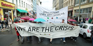Demotransparent mit der Aufschrift „We are the crisis“