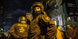 Polizisten und Polizistinnen sthen vor einem bestzten haus in der Berliner Liebigstraße