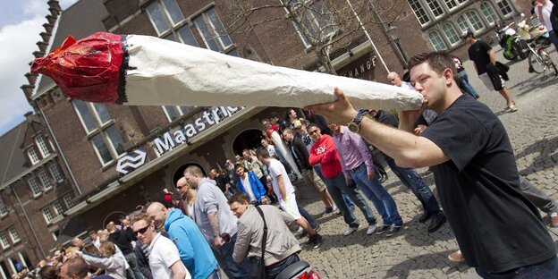 Mann mit riesiger Joint-Attrappe Mann mit riesiger Joint-Attrappe
