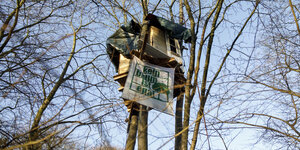 Baumhaus mit Transparent: "Kein Baum ist egal"